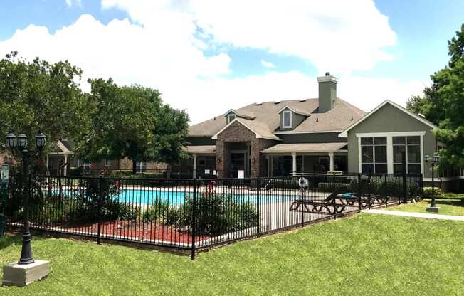 a pool in front of a community room with a fence