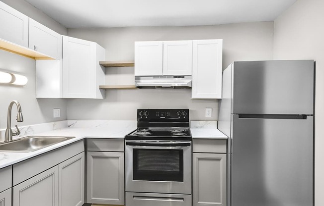 A modern kitchen with stainless steel appliances and white cabinets.