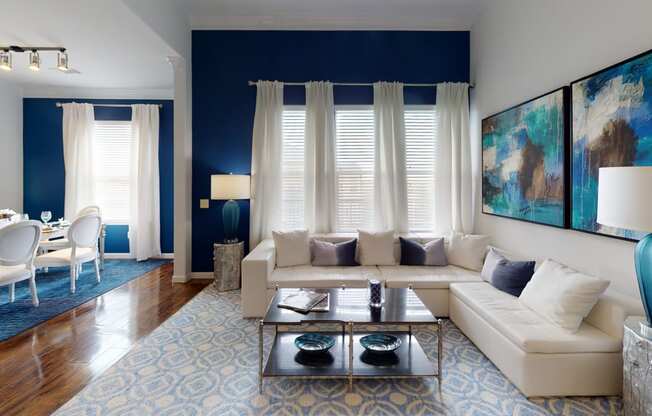 a living room with blue walls and white furniture