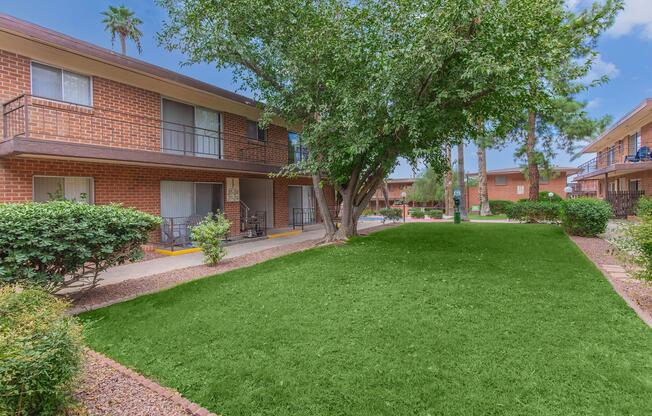 a house with a lawn in front of a brick building