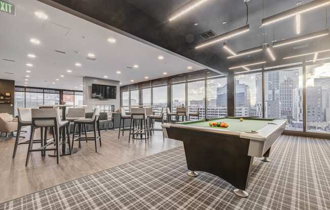 a games room with a pool table and a view of the city