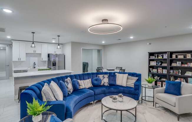 a living room with a blue couch and a kitchen