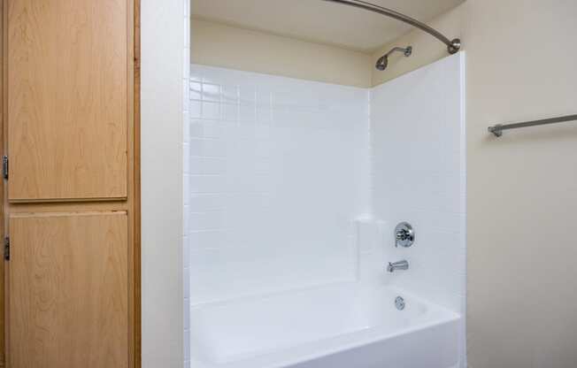 a bathroom with a white tub and shower