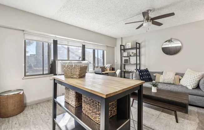 an open living room and dining room with a table and a ceiling fan at Archer Tower in Denver, CO
