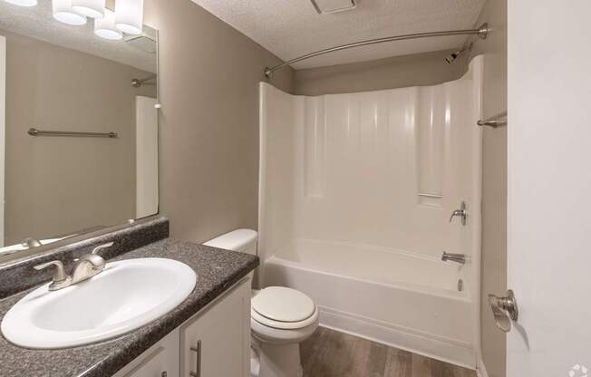 A bathroom with a sink, toilet, and bathtub.