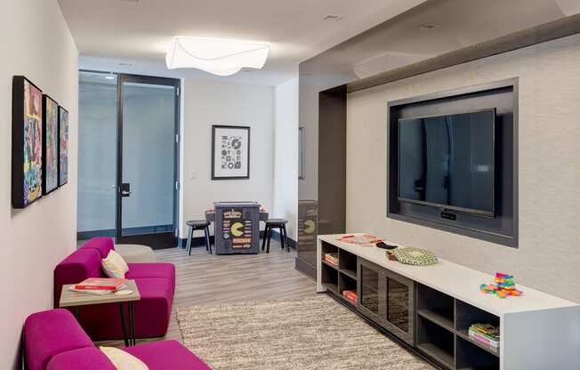 a living room with a purple couch and a television