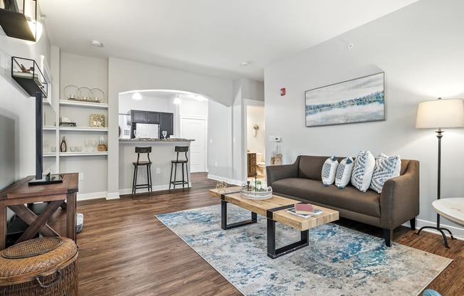 A living room with a brown couch and a blue rug.