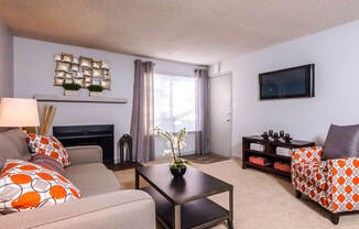 a living room with a couch and a chair and a television at Skyview Apartments, Westminster Colorado