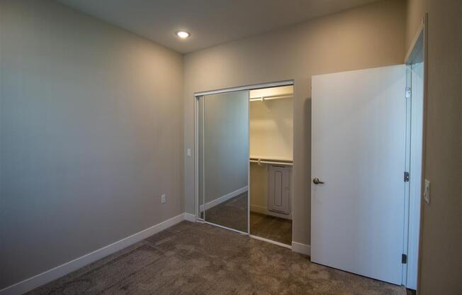 a bedroom with a closet and a mirror at Loma Villas Apartments, San Bernardino