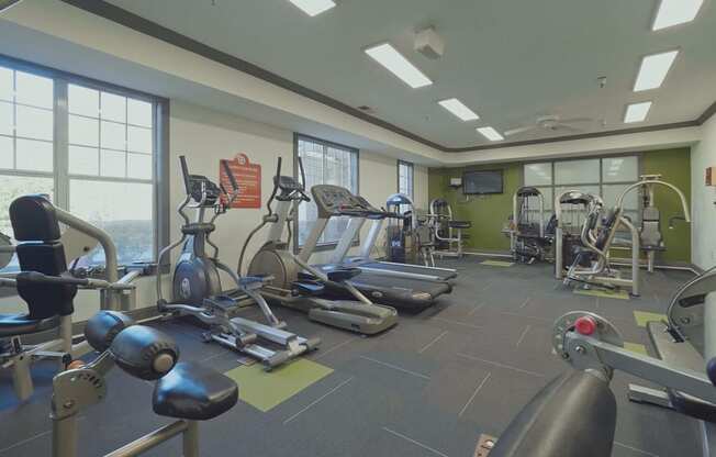 a gym with various exercise equipment and windows