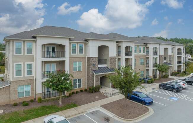 a large apartment building with cars parked in a parking lot