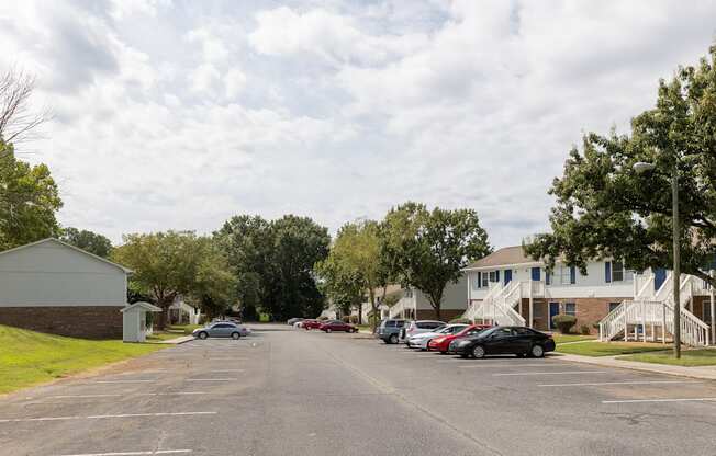 A parking lot with cars and a building in the background.