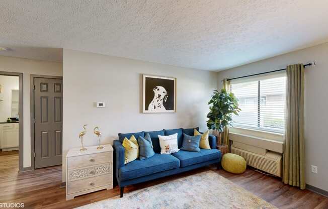 a living room with a blue couch and a window