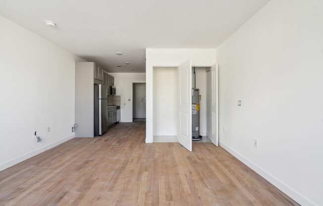 a renovated living room and kitchen with wood floors and white walls