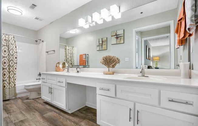 a white bathroom with a large mirror and a sink