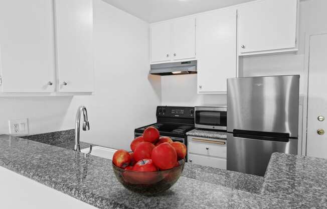 a kitchen with stainless steel appliances and a bowl of apples