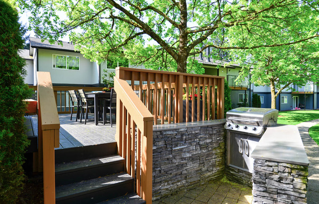 a deck with a grill and a stone wall