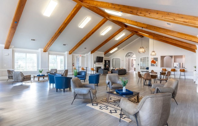 a large living room with high ceilings and chairs and tables