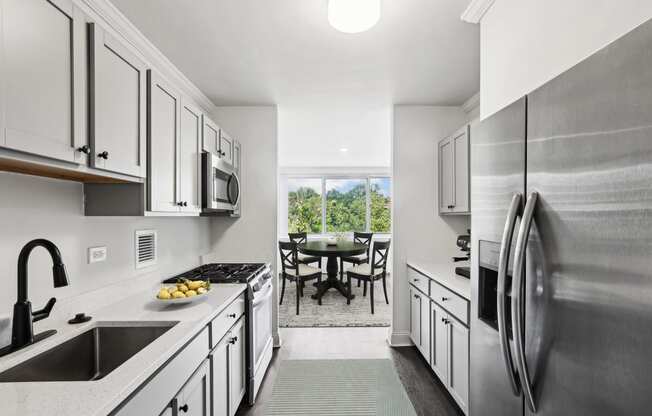 a kitchen with white cabinets and stainless steel appliances and a stainless steel refrigerator