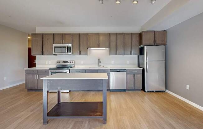 A kitchen with a stainless steel refrigerator and a wooden island.