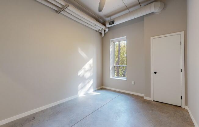 an empty room with a door and a window