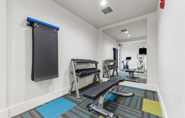 A gym room with a row of exercise equipment.