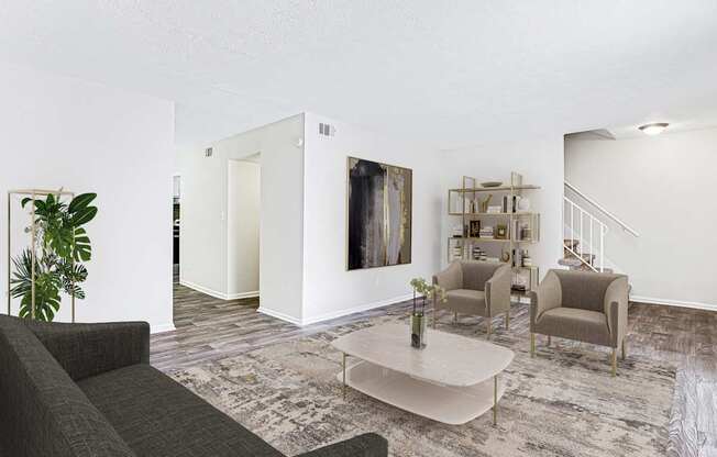 A living room with a grey couch, a coffee table, and a painting on the wall.
