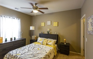 a bedroom with a bed and a ceiling fan