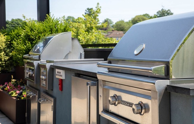 two stainless steel gas grills next to each other on a patio