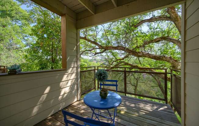 a covered patio with a blue table and chairs at Folsom Ranch Apartments in California