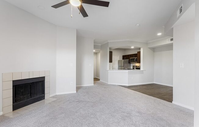 an empty living room with a fireplace and a ceiling fan at The Legends at Eagle Mountain Lake, Texas