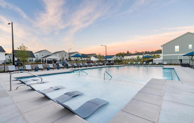 Resort-style pool with spacious sundeck and lounge seating. This image is a representation of the pool with sundeck at Amavi Brier Creek and is tentatively scheduled to open Summer 2025.