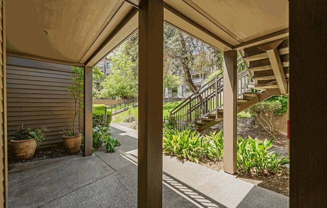 a covered porch with stairs leading up to a house