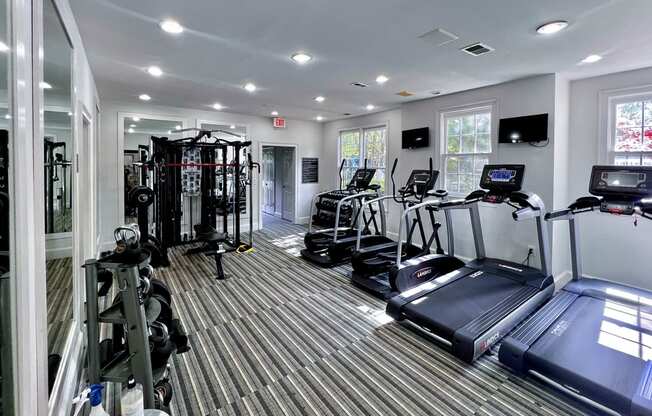 a gym with cardio equipment and a treadmill