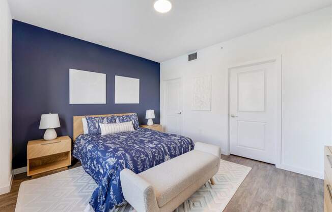 A bedroom with a bed and a blue wall and a white door