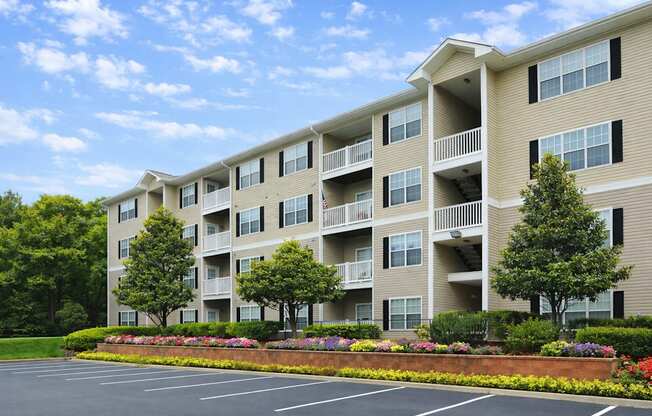 A large apartment building with a parking lot in front.