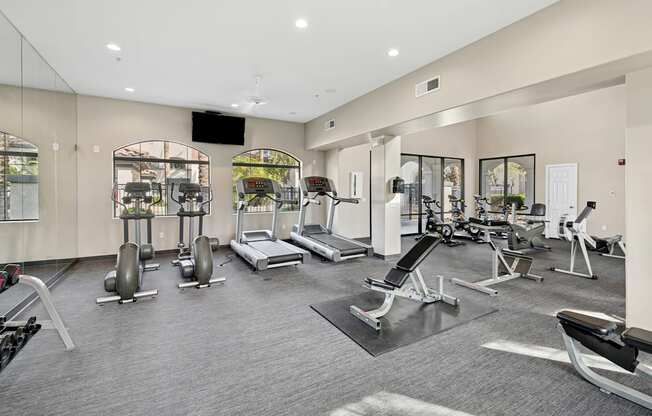 A spacious gym with a variety of equipment including treadmills, weights, and exercise machines.