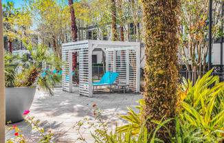 a patio with a blue chair and a white structure