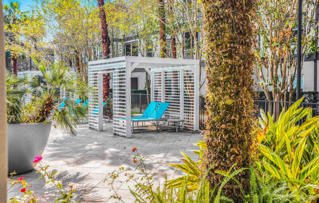 a patio with a blue chair and a white structure