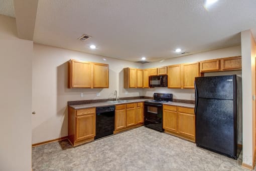 a kitchen with black appliances and wooden cabinets