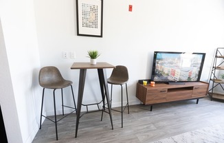 a living room with two stools and a table and a tv