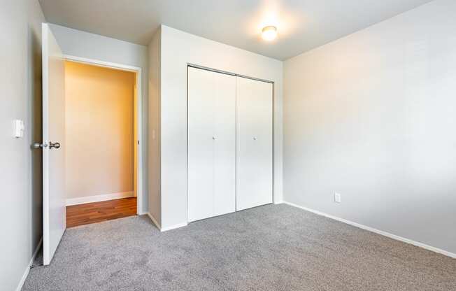 a bedroom with white walls and gray carpet
