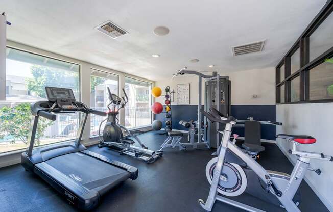 A well-equipped home gym with a treadmill, exercise bike, and other fitness equipment.