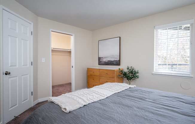 an empty bedroom with a bed and a closet