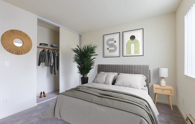 A bedroom with a large bed and a plant.