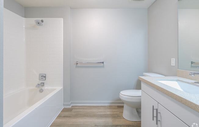 A white bathroom with a toilet, sink, and bathtub.