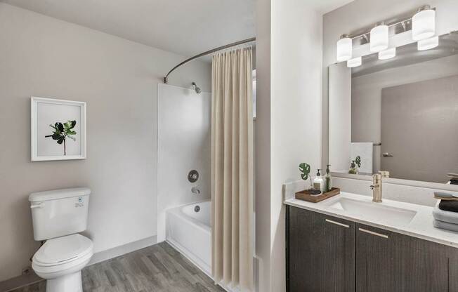 A white toilet sits next to a white bathtub in a bathroom.