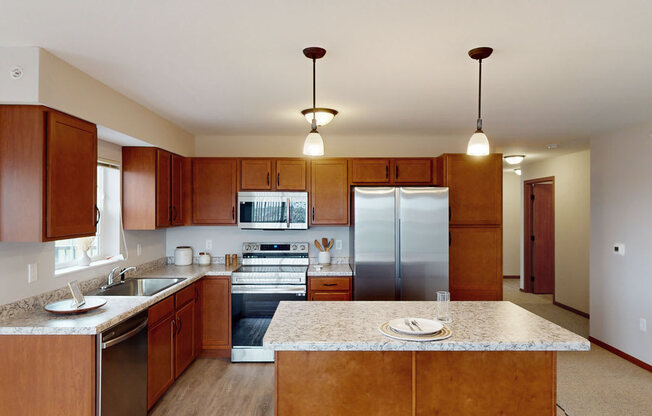 a large kitchen with stainless steel appliances and granite counter tops