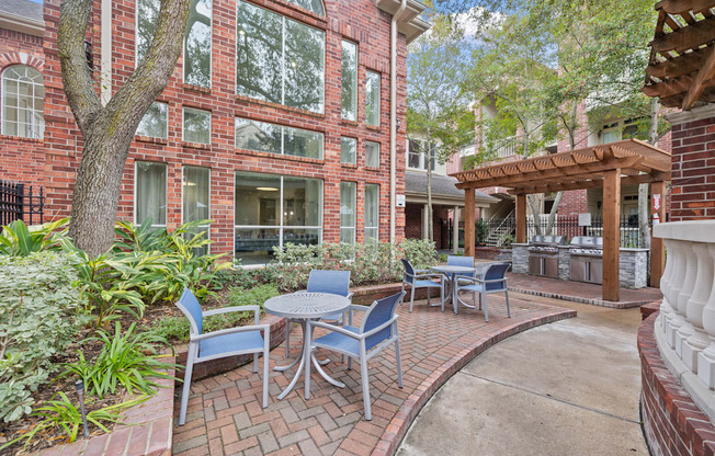 A patio with tables and chairs near outdoor grills