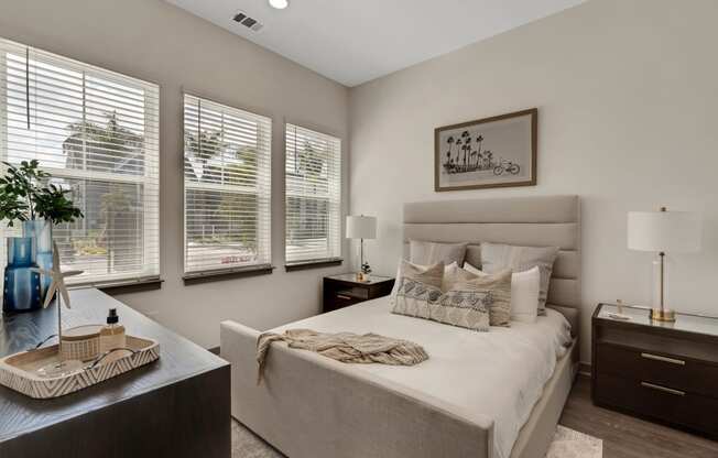 a bedroom with a bed and three windows  at The Sophia, Florida
